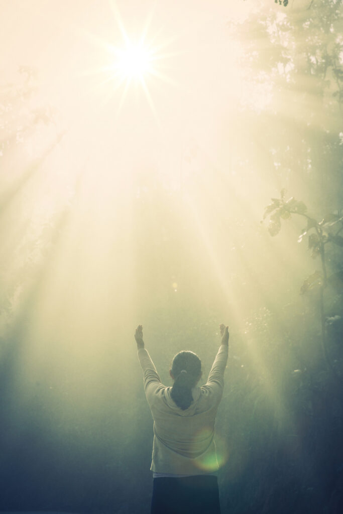 young girl meditate green forest with sunlight Nuestra Historia